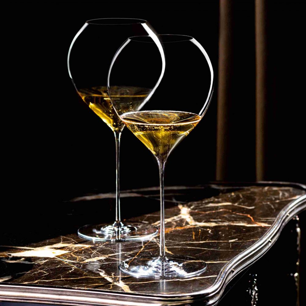 To Synergie 75 cl champagneglass fra Lehmann på mørkt bord.