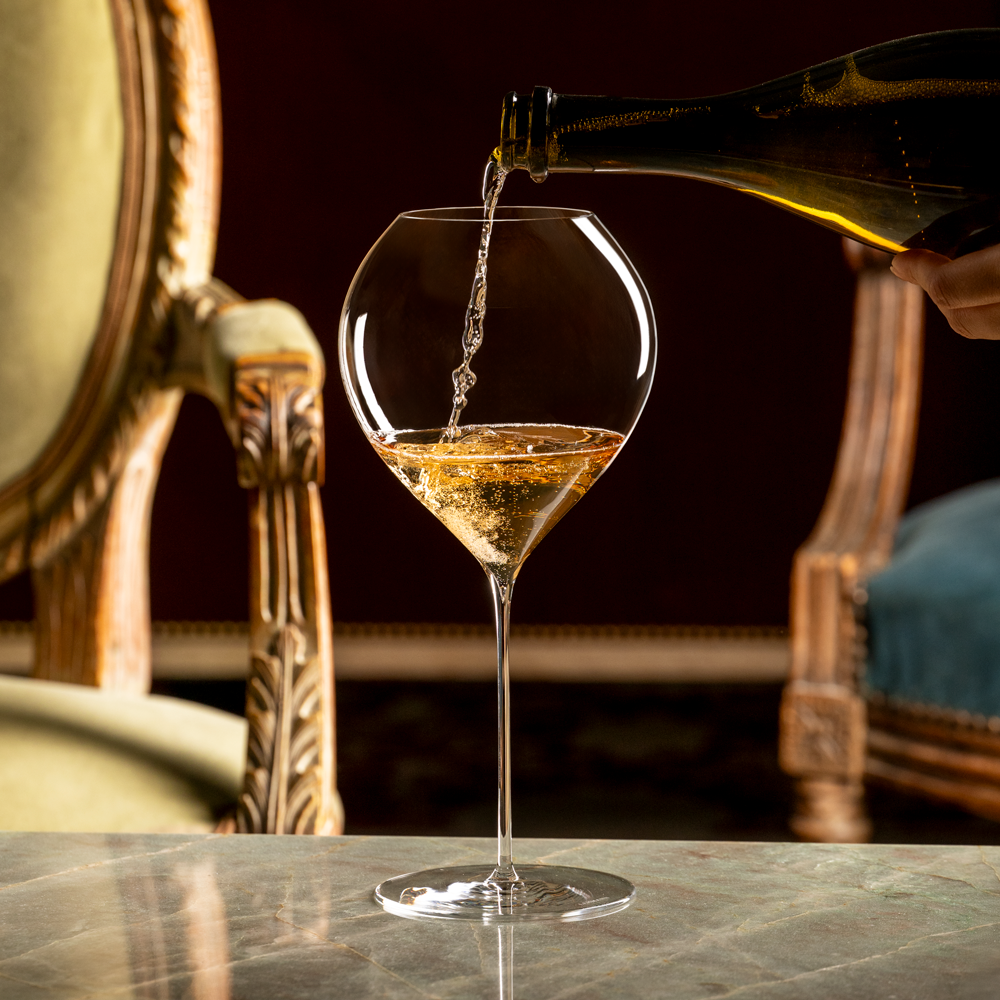 Synergie 75 cl glass med musserende vin på marmorbord.